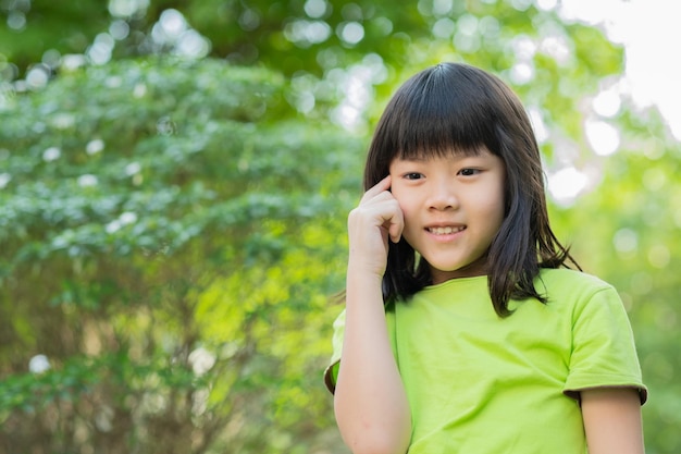 肖像画アジアの子供の子供は、女の子が子供を考えて笑っているのを楽しんで幸せです