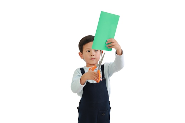 Portrait of Asian little boy craft work by scissors cut the color paper over white background. Image with Clipping path.