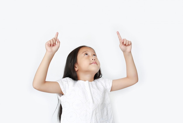 Portrait of Asian little child girl pointing two forefinger up and looking above isolated