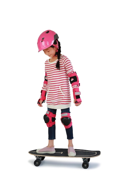 Portrait of Asian little girl skateboarder with wearing safety and protective equipment stand on skateboard isolated on white background Image with Clipping path