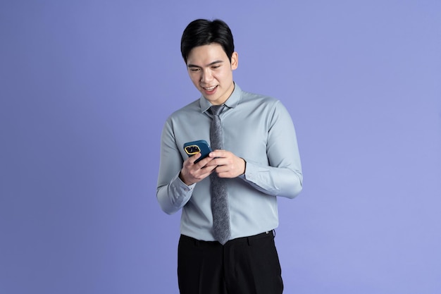 Photo portrait of asian male businessman posing on purple background