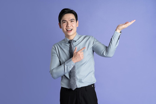 Photo portrait of asian male businessman posing on purple background