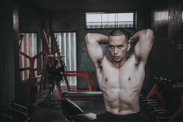 Ritratto di uomo asiatico grande muscolo in palestrapopolo thailandeseallenamento per una buona saluteallenamento con il peso corporeofitness in palestra concettoprank ai muscoli addominalisollevamento della campana di sollevamento allenamento del tricipite