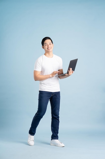 Portrait of asian man posing on blue background