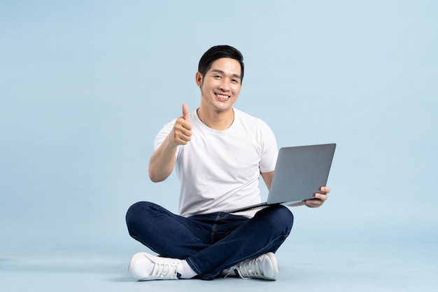 Portrait of asian man posing on blue background