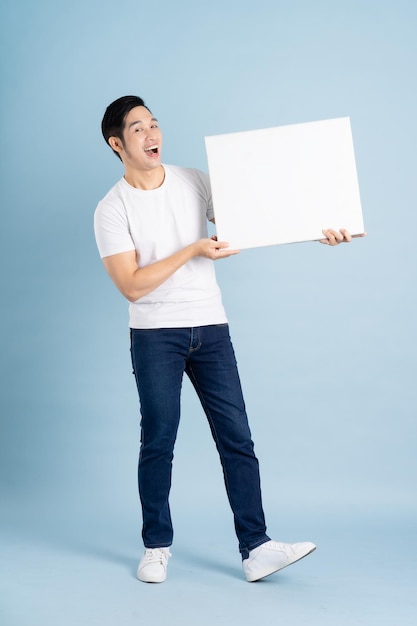 Portrait of asian man posing on blue background
