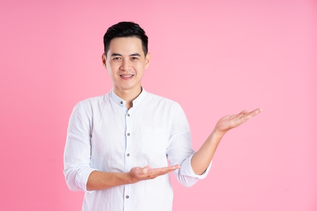 Portrait of asian man posing on pink background