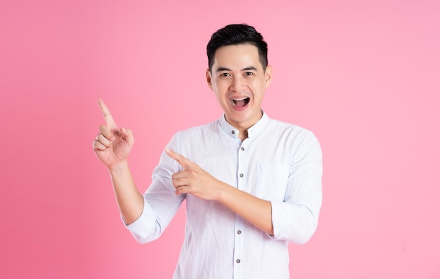 Portrait of asian man posing on pink background