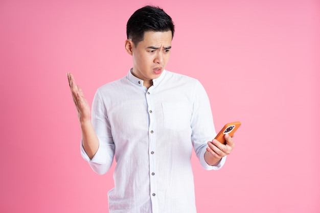 Portrait of asian man posing on pink background