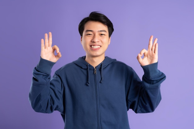 Portrait of asian man posing on purple background