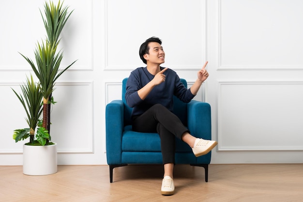 Portrait of asian man sitting on sofa at home