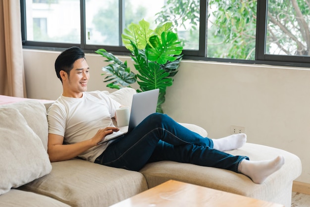 Portrait of asian man sitting on sofa at home