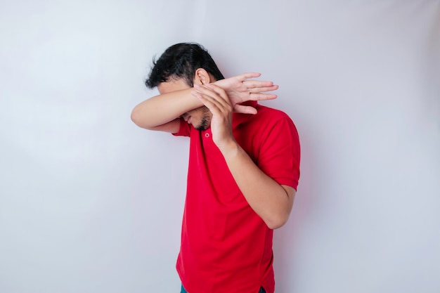 A portrait of an Asian man wearing a red tshirt isolated by white background looks depressed