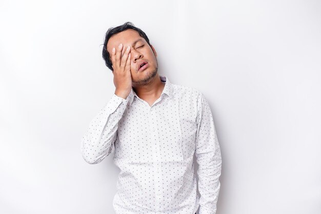 A portrait of an Asian man wearing a white shirt isolated by white background looks depressed