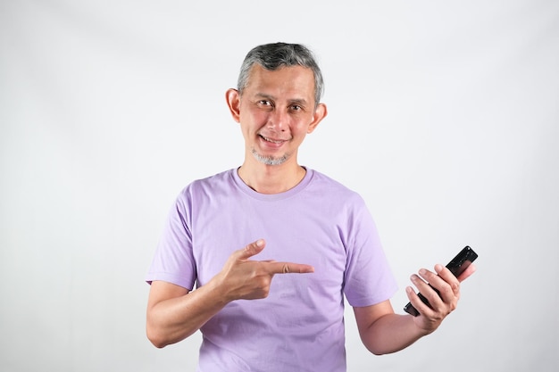 Portrait of Asian man with purple tshirt holding the cellphone showing the application