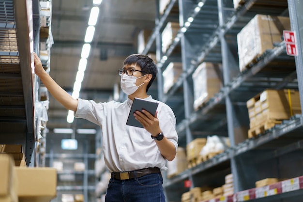 Portrait asian men, staff, product counting warehouse control
manager standing, counting and inspecting products in the
warehouse