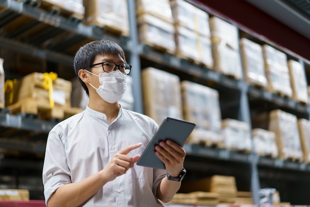 Portrait asian men, staff, product counting warehouse control\
manager standing, counting and inspecting products in the\
warehouse