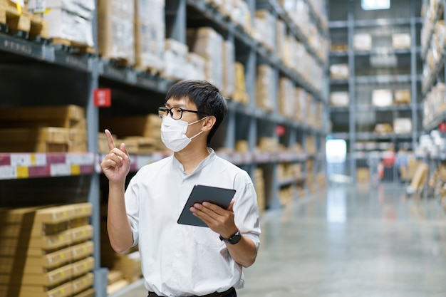 Portrait asian men, staff, product counting warehouse control\
manager standing, counting and inspecting products in the\
warehouse