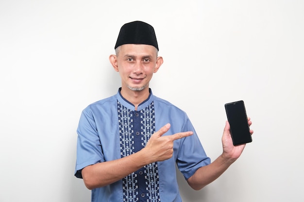 Портрет азиатского мусульманина, держащего мобильный телефон и показывающего приложение