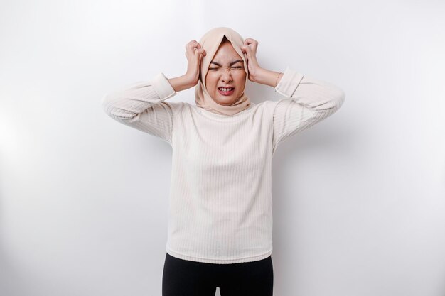 A portrait of an Asian Muslim woman wearing a headscarf isolated by white background looks depressed