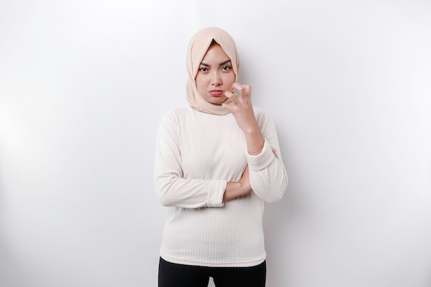 A portrait of an Asian Muslim woman wearing a headscarf isolated by white background looks depressed