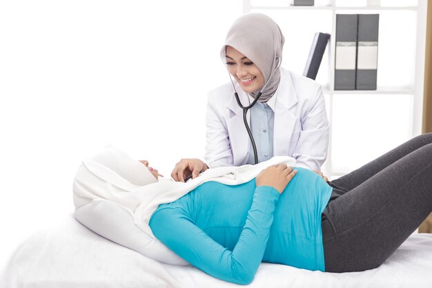 Portrait of asian obstetrician checking patients heart beat