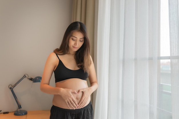 Ritratto di donna incinta asiatica in camera da letto