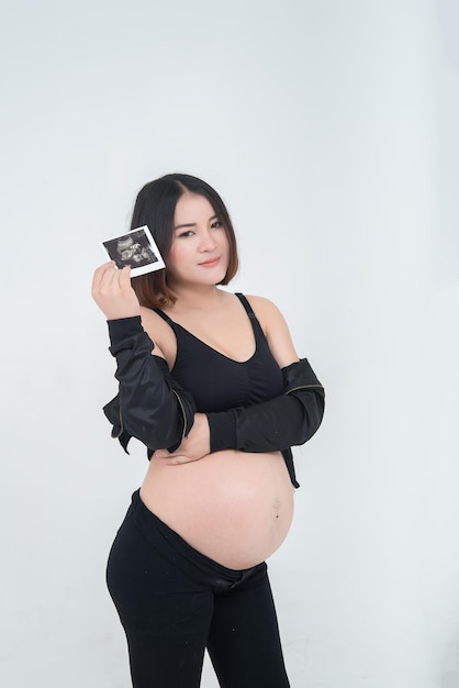 Portrait of asian pregnant woman on white backgroundthailand peopleultrasound photo in her hand