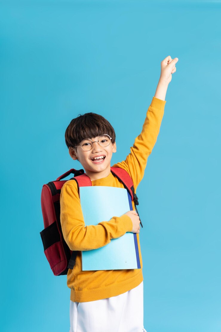 Photo 青色の背景に生まれたアジアの学校の男の子の肖像画