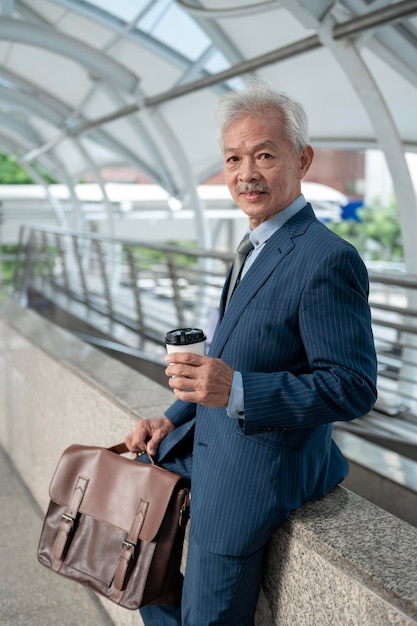 Portrait of Asian senior mature middle aged businessman in modern city