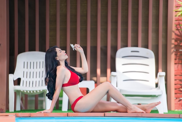 Portrait of asian sexy woman at swimming poolThailand has a slim body shapeHealthy woman conceptFashion bikini summer