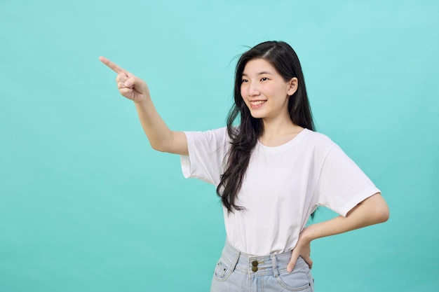 Portrait of Asian teen beautiful young woman smile laughing point finger side away blank copy space