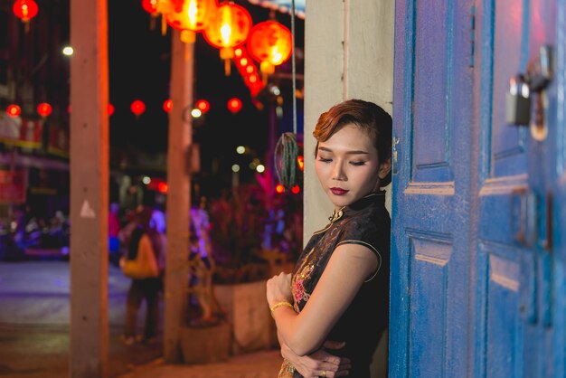 Portrait of asian woman in black dress on the walkway in downtown night sceneclose up a girl street style