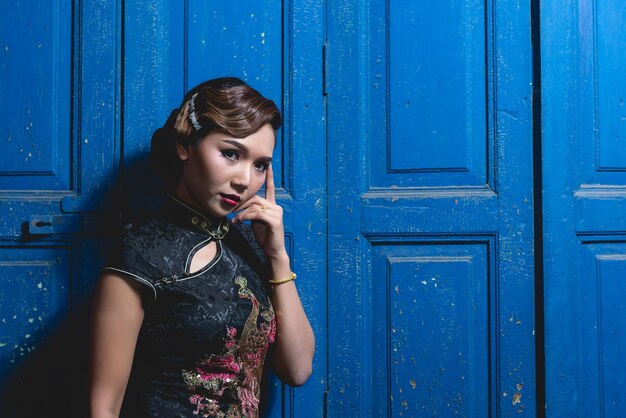 Portrait of asian woman in black dress on wooden door background night scene