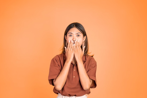 Portrait of asian woman covering her mouth with hands