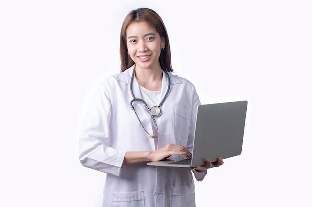 Portrait of Asian woman doctor wearing uniform holding laptop stand isolated on white background Female medical nurse or practitioner with stethoscope look at camera