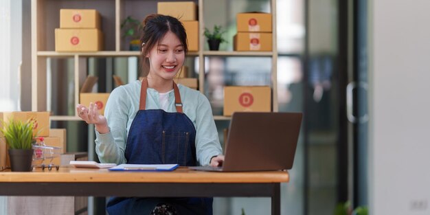 A portrait of Asian woman ecommerce employee freelance with parcel box for deliver to customer Online marketing packing box delivery concept