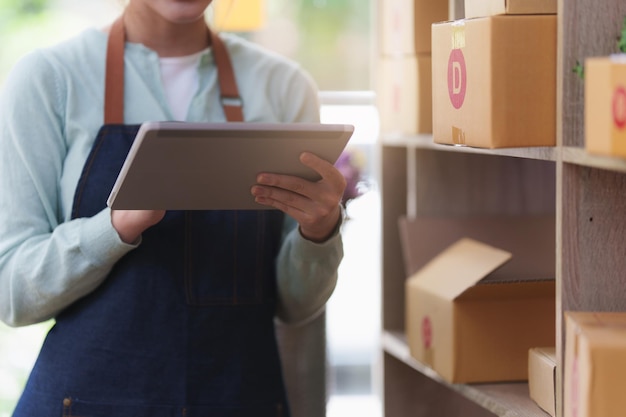 A portrait of Asian woman ecommerce employee freelance with parcel box for deliver to customer Online marketing packing box delivery concept