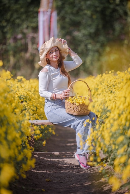 菊の花畑で休暇を楽しんでいるアジアの女性の肖像画