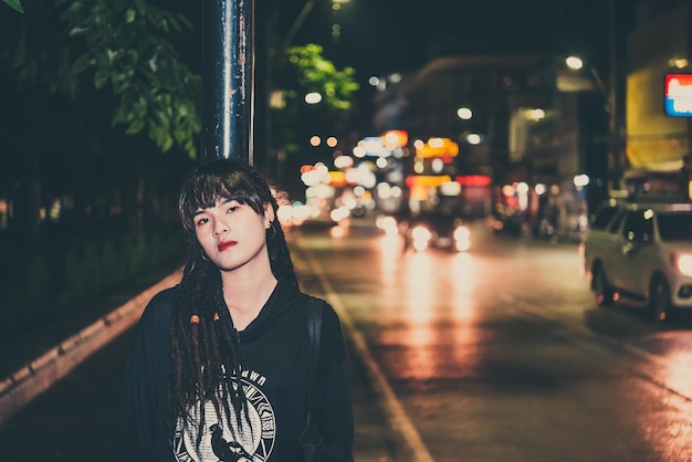 Portrait of asian woman hair dreadlock night scene in the cityThailand people pose for take a photofeeling lonelysad woman concept