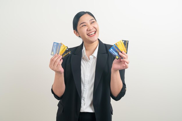 白い背景のクレジットカードを保持している肖像画アジアの女性