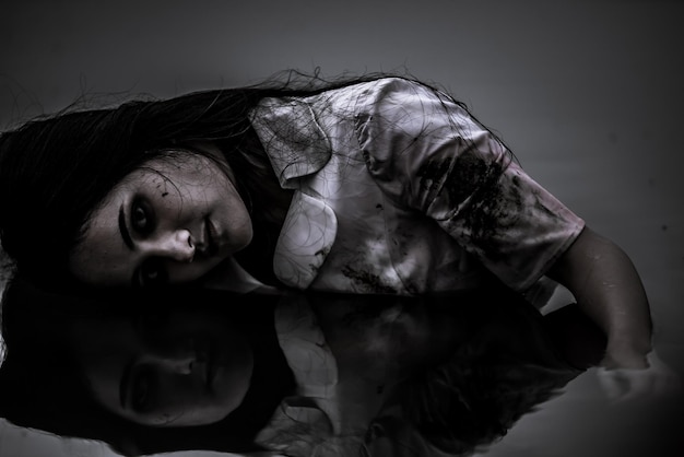 Portrait of asian woman make up ghost face at the swamHorror sceneScary background