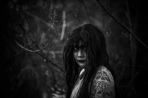 Portrait of asian woman make up ghost face at the swampHorror in water sceneScary at riverHalloween posterThailand people