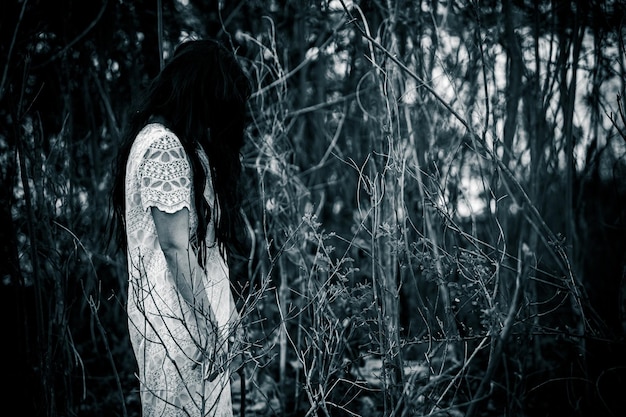 Portrait of asian woman make up ghost face at the swampHorror in water sceneScary at riverHalloween posterThailand people