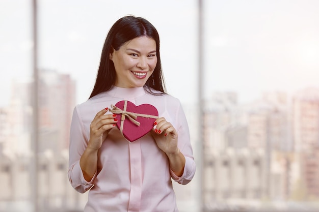 Portrait of asian woman showing heart shape gift box