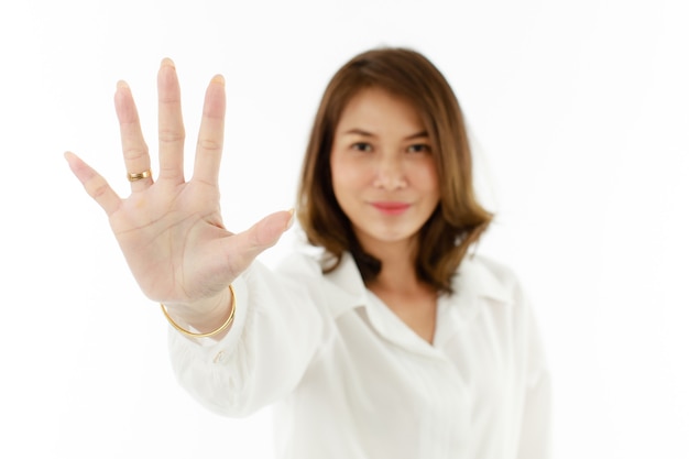 Portrait of Asian woman showing his five fingers for number 5 or prohibit, refuse manner. Selective focus on hand.