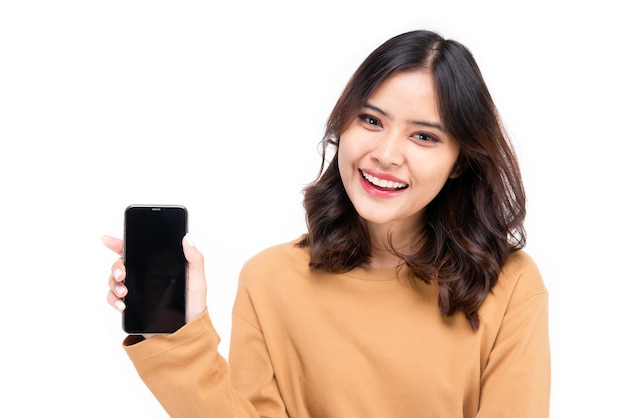 Foto ritratto di donna asiatica che mostra o presenta l'applicazione del telefono cellulare a portata di mano su sfondo bianco, bella donna che sembra sana, sicura di sé isolato su bianco.