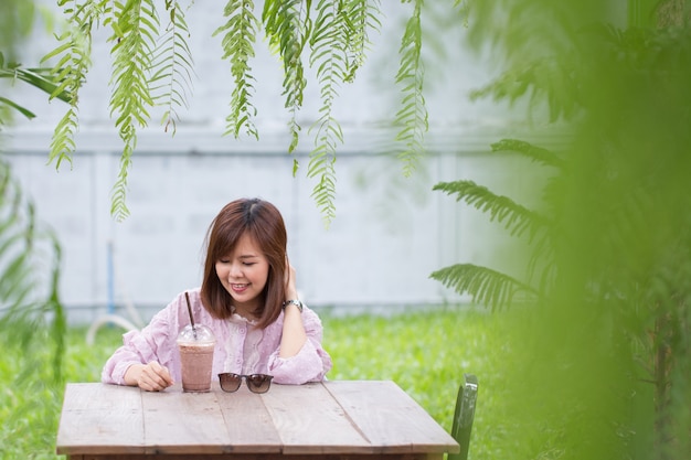 Foto donna asiatica del ritratto che sorride nella caffetteria.