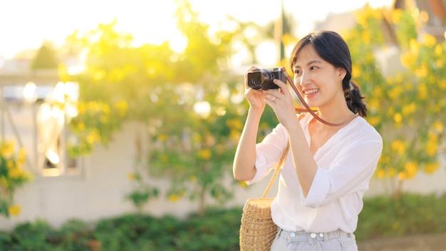 Photo portrait of asian woman traveler using camera at street of bangkok thailand asia summer tourism vacation concept