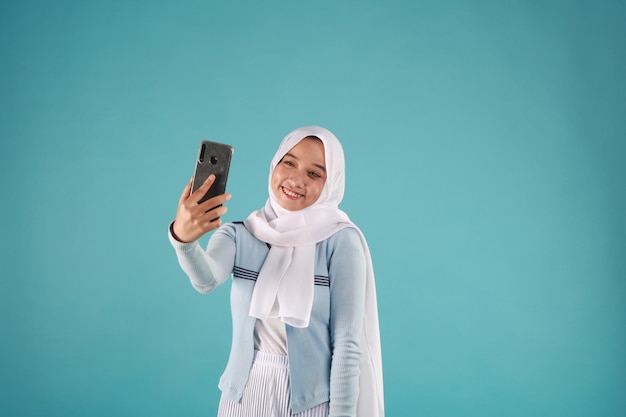 portrait of Asian Woman using smartphone on blue background